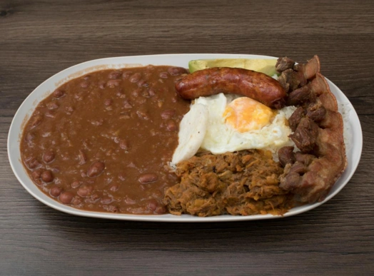 Bandeja Paisa completa con frijoles, chicharrón, arepa y aguacate